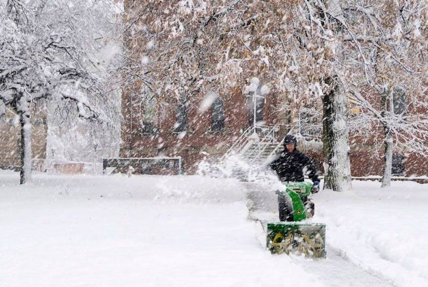 A man uses a snow blower in front of the Coles building in downtown Charlottetownon Wednesday Nov. 30, 2016. A messy mix of snowfall and cold rain has caused power outages, school closures and flight cancellations today in the Maritimes.