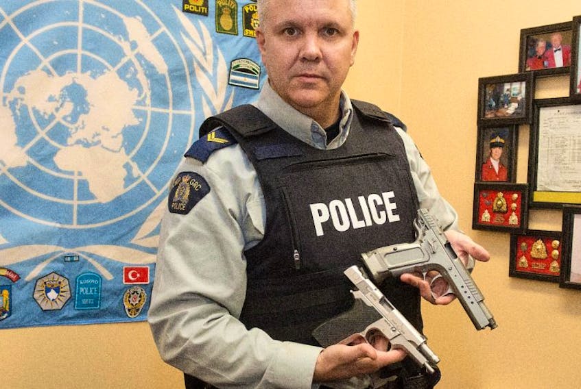 BRIAN MCINNIS/TC MEDIA

Cpl. Chris Gunn, of the Queens District RCMP, displays an RCMP issued service pistol, left, and the pellet gun seized following an incident in Cornwall Thursday. He was demonstrating how real looking the pellet gun looks.