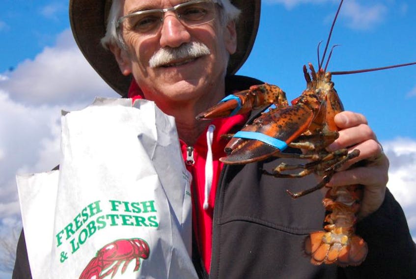 JIM DAY/THE GUARDIAN Philip Jost of Charlottetown bought his first lobster of the season from Campbell's Deep Sea Fishing that was selling the crustaceans from the back of a truck in a mall parking lot in Stratford. The lobster was selling for $7.50 per pound for canners and $8.50 per pound for market.