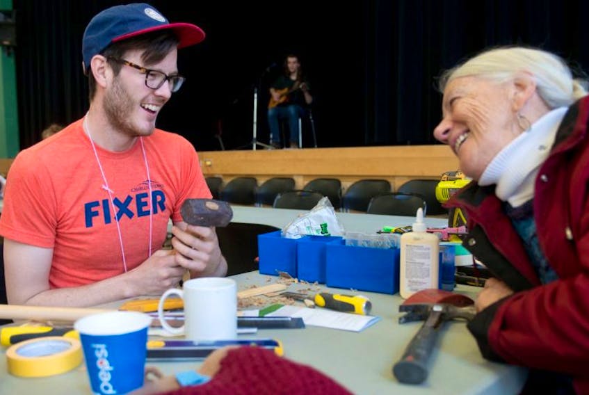 ['Volunteer fixer Patrick Callbeck, left, repairs a hammer for Denise Motard during the Fix It Fair held at Murphy’s Community Centre on Saturday.']