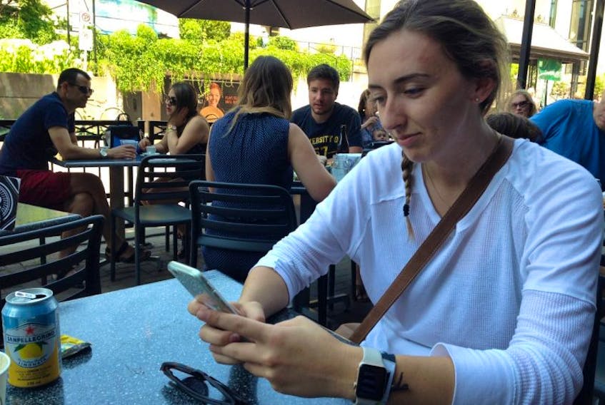 Anneliese Surmann uses the Wi-Fi connection at Receiver Coffee on her phone Friday during a widespread cellphone service outage. 