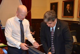 Charlottetown City Coun. Mitchell Tweel, right, confers with Frank Quinn, manager of parks and recreation, prior to Monday night's city council meeting.