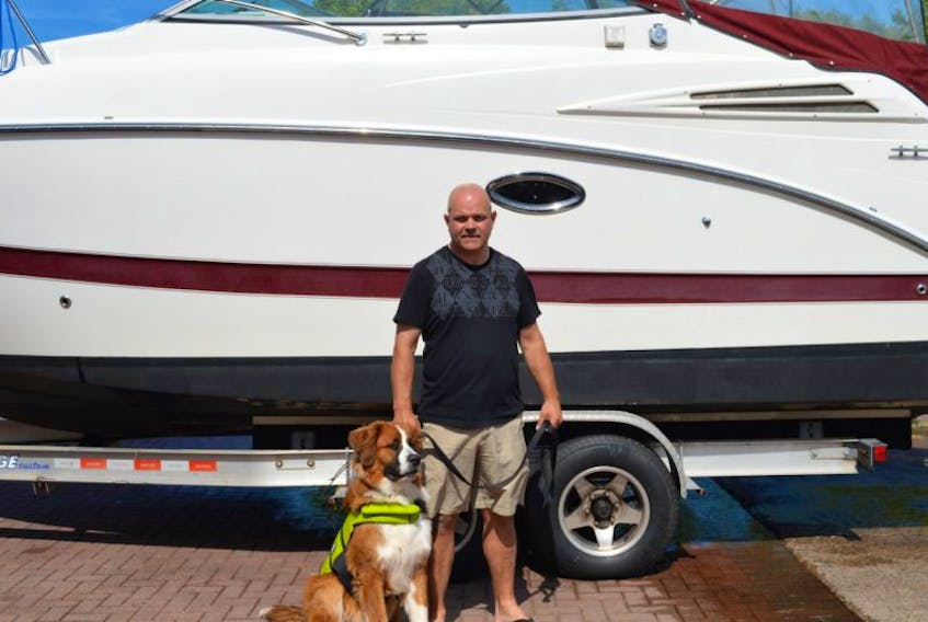Wade Martell of North Wiltshire maintained a calm demeanor after his boat “Escape” began taking on water. He's pictured here with his dog, Tugboat.   

