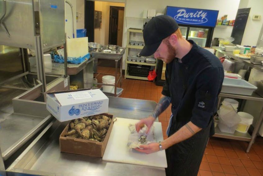 Brennan Roy, cook at the Pilot House Restaurant, shucks a fresh oyster from Prince Edward Aqua Farms, P.E.I. Atlantic oyster sales have seen a dramatic increase with the outbreak of Norovirus in west coast oysters.