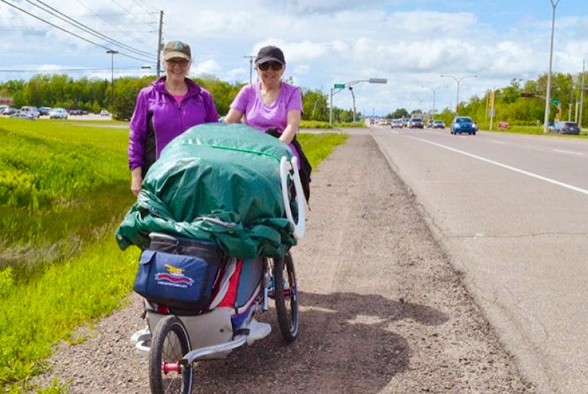 Bernadette Shea, left, and her sister, Dolly Pigeon, push a jogging stroller along Route 2 in Stratford on their way to Wood Islands on June 13.