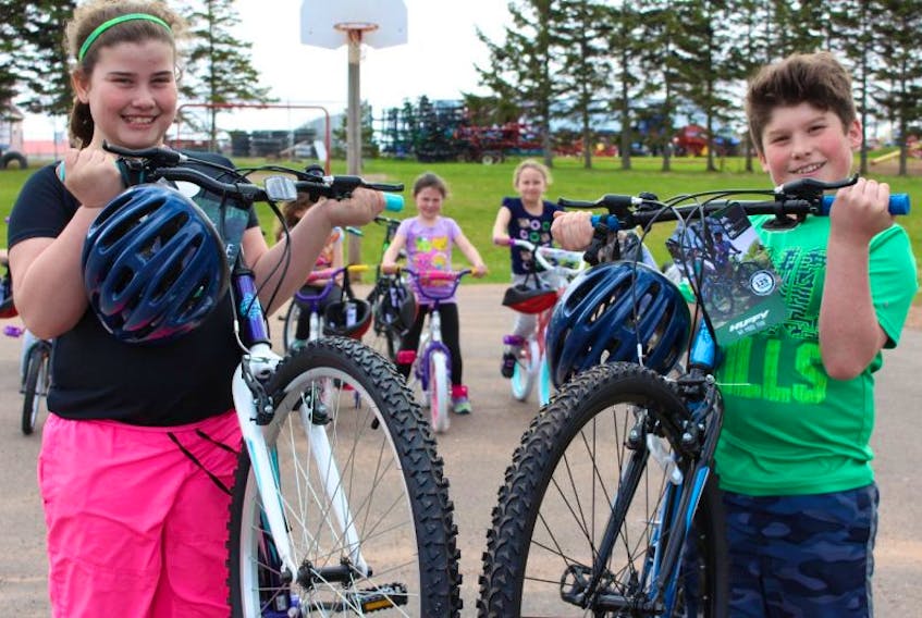 Megan Moase, left, and Brayden Carruthers show off their bikes with their schoolmates in the background.
