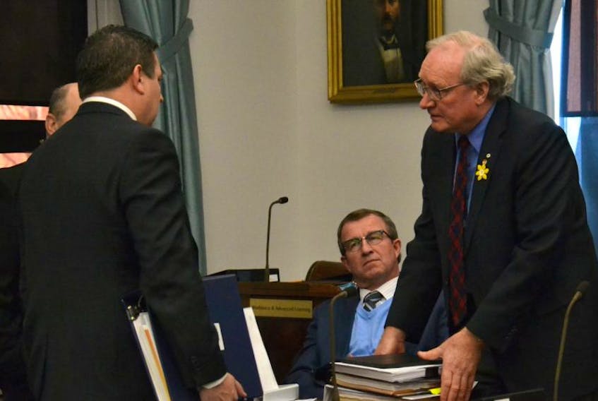 P.E.I. Premier Wade MacLauchlan, right, speaks to MLAs Alan McIsaac, centre, and Matthew MacKay in the legislature Wednesday. 