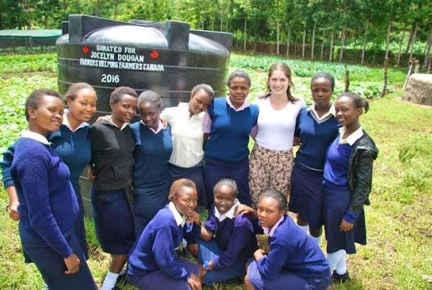 Jocelyn Dougan is joined by Kenyan friends in front of a water tank donated as a show of support by family and friends back home on P.E.I.