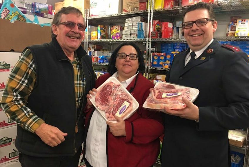 Robbie Paynter, left, of the agriculture union, with Neil Abbott and Delores Abbott of the Salvation Army Food Bank in Summerside.  
