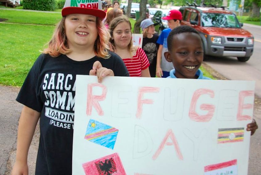 Jushua Gasana, right, is joined by Dylan Harvey in a walk Tuesday to celebrate World Refugee Day by students and staff of St. Jean Elementary school in Charlottetown and staff of the P.E.I. Association for Newcomers to Canada. Joshua, 10, grew up in a refugee camp in Uganda before starting a new life in Prince Edward Island in 2015.