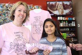 Allison Doughart, with P.E.I. Crimestoppers, left, was selling anti-bullying T-shirts Wednesday to students at Holland College, including Arpana Giri. Feb. 22 was Pink Shirt Day, in support of those who have been bullied.