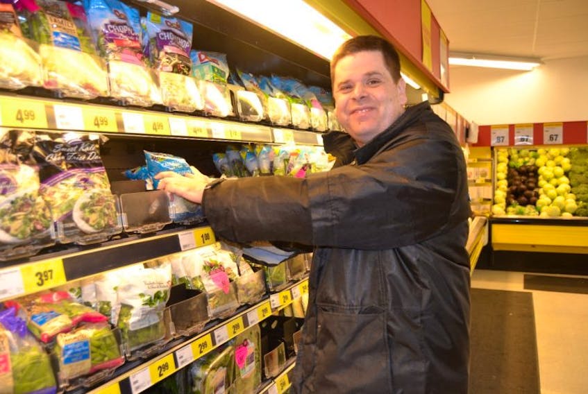 Greg Allen stocks the produce shelves at Shawn's No Frills in Stratford. Allen, who has autism, has an active life. He plays field hockey, swims and goes hiking on the trail with his family.  His volunteer job recently turned into a paying one.
