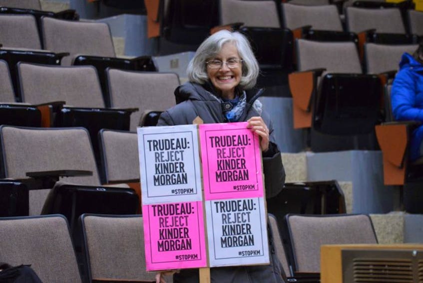 Mary Cowper-Smith holds a protest sign during a vigil held at UPEI in Charlottetown on Nov. 21, 2016 to oppose the expansion of the Kinder Morgan pipeline in western Canada.