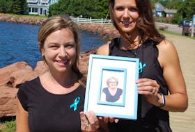 Jillian Forbes, left, and her sister Jennifer Bowness hold a photo of their late mother Cheryl Clark, who died of ovarian cancer in March. The sisters are organizing the first annual Ovarian Cancer Walk of Hope in Charlottetown in memory of mom.