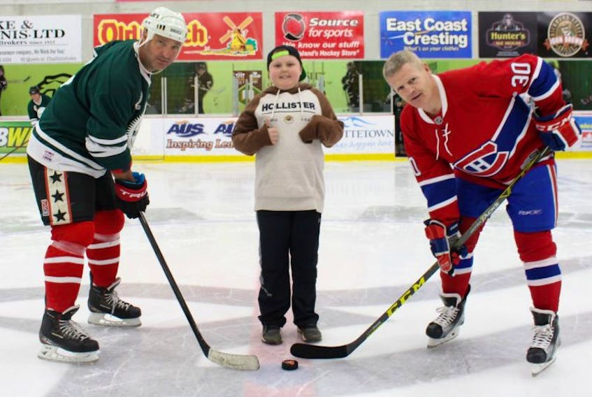 Griffin Read, 12, of Summerside, prepares to drop the puck between former NHL players Stephane Richer, left, and Chris Nilan, at the annual Vector Aerospace Face Off Against Cancer hockey tournament, which raised $64,000 for the Canadian Cancer Society. 