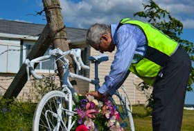 Edmund Aunger places a wreath on the bike he was riding the day his wife Elizabeth Sovis during a cycling trip in P.E.I. in 2012. Aunger held a memorial service in Hunter River on Friday to mark the five-year anniversary of his wife’s death. About 100 people attended a service at Central Queens United Church in Hunter River before a procession that included cyclists made their way to the place where she died several kilometres away on Route 13. Aunger left his bike, which was painted white and called a ghost bike, behind as a memorial to Sovis. 