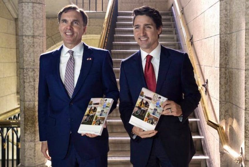 Finance Minister Bill Morneau and Prime Minister Justin Trudeau hold copies of the federal budget in the House of Commons in Ottawa March 22, 2017.  
