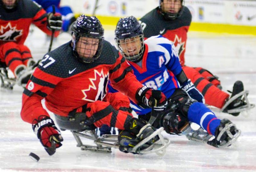 Team Canada defenceman Brad Bowden, left, keeps the puck away from Team Korea forward Seung-Hwan Jung during a preliminary match in the 2016 World Sledge Hockey Challenge at Charlottetown’s MacLauchlan Arena Monday night.