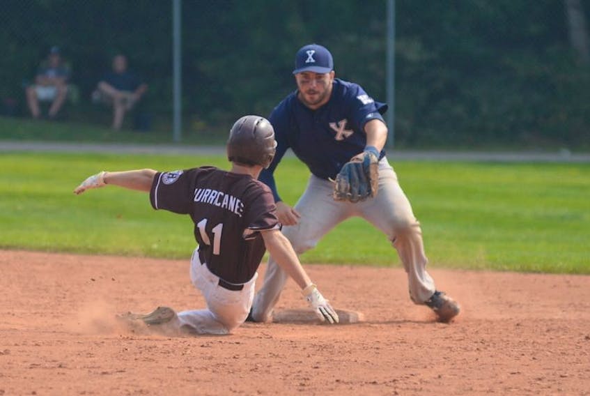 St. FX X-Men second baseman Tim MacKinnon prepares to tag Matt Barlow of the Holland College Hurricanes during Saturday’s first game of a doubleheader at Memorial Field. Barlow was called safe on the play.