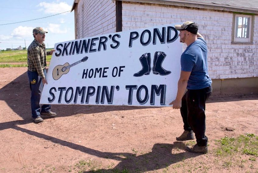 Workers move a sign at the site of the proposed Stompin Tom Connors cultural centre in Skinners Pond, P.E.I. on Wednesday, Aug. 3, 2016. More than two decades after the residents of Skinners Pond, P.E.I., began trying to scrape together the money to build a centre dedicated to the music and life of their most famous son, the Stompin' Tom Centre will open its doors on Canada's 150th birthday. 