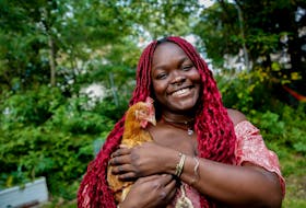 Francesca Ekwuyasi, author of Butter Honey Pig Bread, in the backyard of her Halifax home, with one of her three chickens Tuesday September 29, 2020.

TIM KROCHAK PHOTO