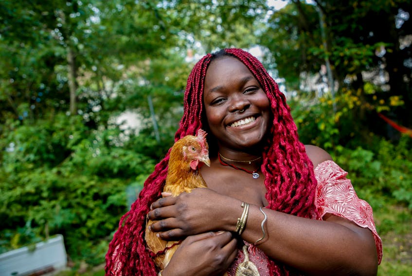 Francesca Ekwuyasi, author of Butter Honey Pig Bread, in the backyard of her Halifax home, with one of her three chickens Tuesday September 29, 2020.

TIM KROCHAK PHOTO