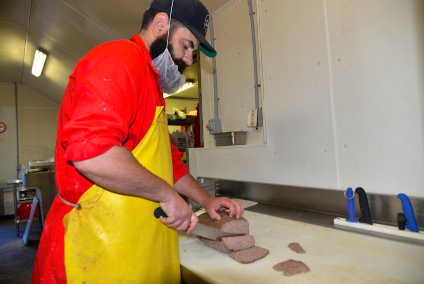 Mike Doiron, co-owner of Founders’ Delicatessan, cuts some Donair meat recently made for a local pizza restaurant. Doiron now works out of Mount Stewart, P.E.I. after deciding not to return to his previous location in Charlottetown.