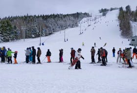 Skiers and snowboarders line up for the lift at the base of Ski Wentworth on opening day Jan 4. People are required to wear masks except while skiing, snowboarding or on the lift and must remain two metres apart, except within their  bubbles.