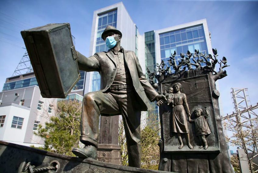 The sculpture, The Emigrant, by Armando Barbon, has been accessorized, near the Seaport Market in Halifax on Monday, May 25, 2020. Refugee advocates say they are concerned about what happens to asylum seekers if they are returned to the U.S.