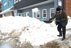 Nathan Quinn of Alder Point clears the sidewalk in front of J. Francis Investments on George Street, Sydney, Friday. A record 179.8 cm of snow was registered at the Sydney airport in January, the most since records have been kept dating back to 1870. Sharon Montgomery-Dupe/Cape Breton Post