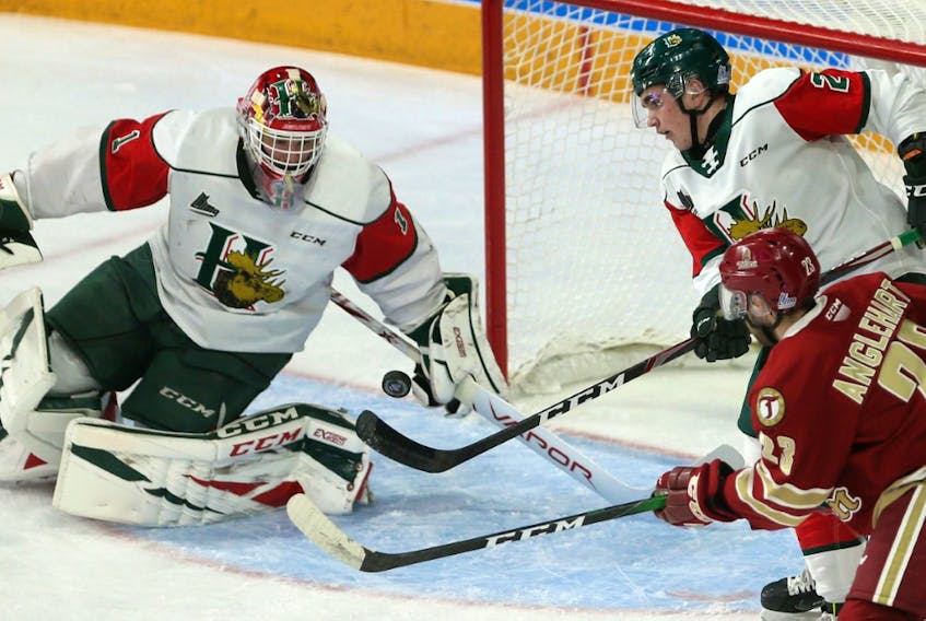 Halifax Mooseheads defenceman Brendan Tomilso, bats away a bouncing puck in front of goalie Alexis Gravel and Bathurst Titan rorward Remy Anglehart during QMJHL action at the Scotiabank Centre on Saturday. (TIM KROCHAK/Chronicle Herald)
