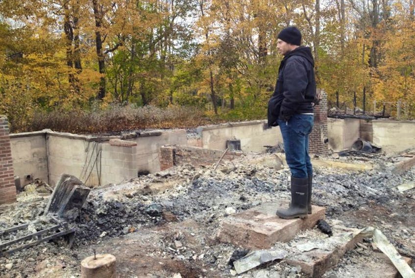 <p>Cecil Flowers, a former resident of the historic property that burned down in Tignish Halloween night, surveys the rubble. The fire is believed to be suspicious, and the RCMP is investigating.&nbsp;</p>