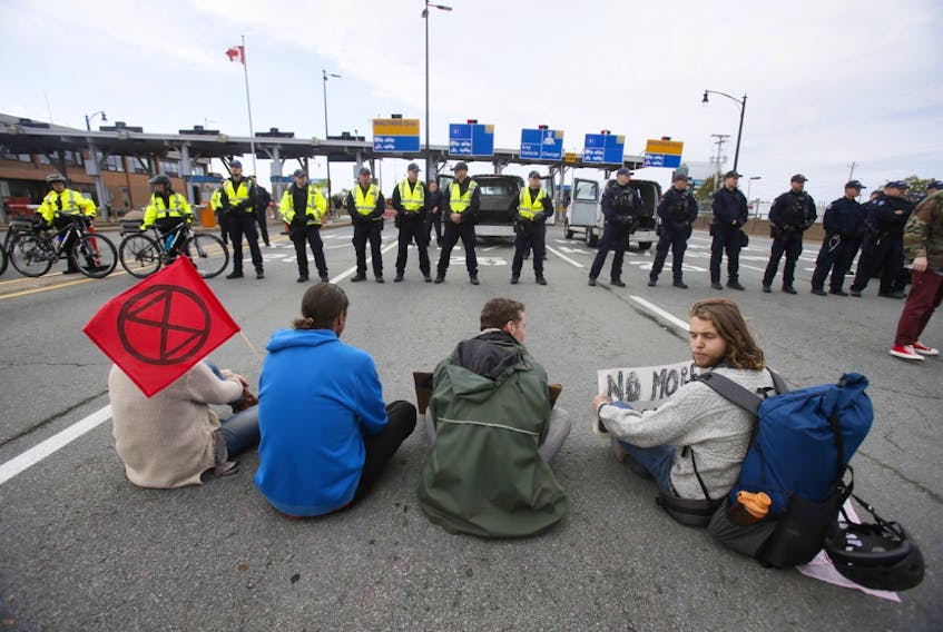 A small group of protesters refuse to stop their blockade of the Macdonald bridge in Dartmouth on Monday, Oct. 7, 2019, as police move in to make arrests. - Tim Krochak