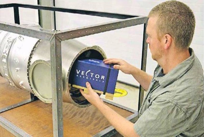 <p>Cohen Hussey loads an item into a unique time capsule his employer, Vector Aerospace Atlantic, is getting ready to seal up for the next 25 years.</p>
<p>&nbsp;</p>