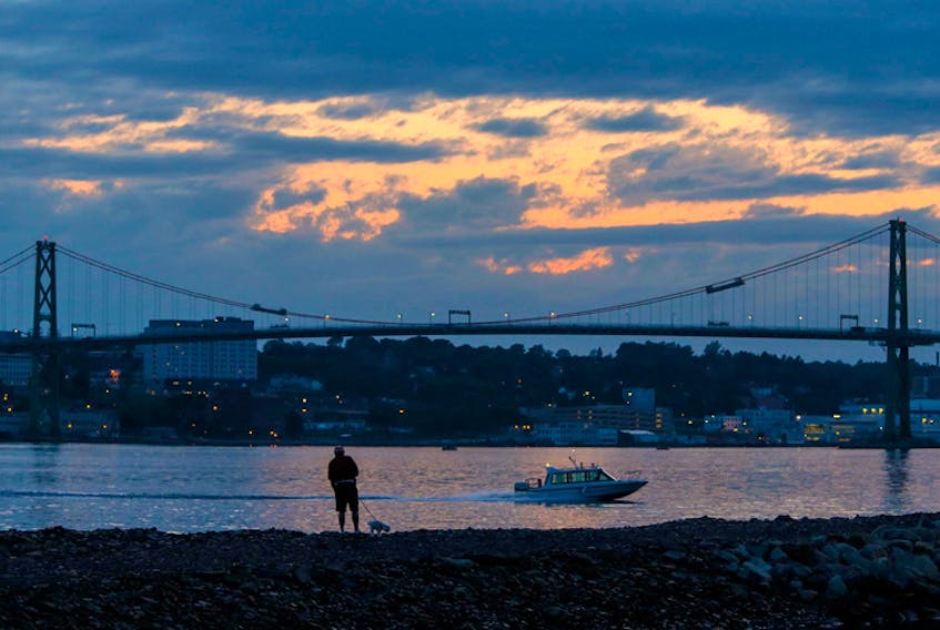 A man walks his dog at dusk, along the jetty at King's Wharf in Dartmouth in this August, 2017 file photo. - Tim Krochak