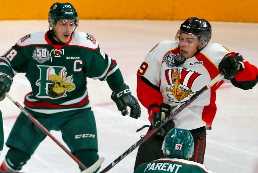 Baie-Comeau Drakkar’s Nathan Legare tastes some rubber from a deflected shot in front of Halifax Mooseheads centre Antoine Morand during QMJHL action at the Scotiabank Centre on Satruday. (TIM KROCHAK/STAFF)