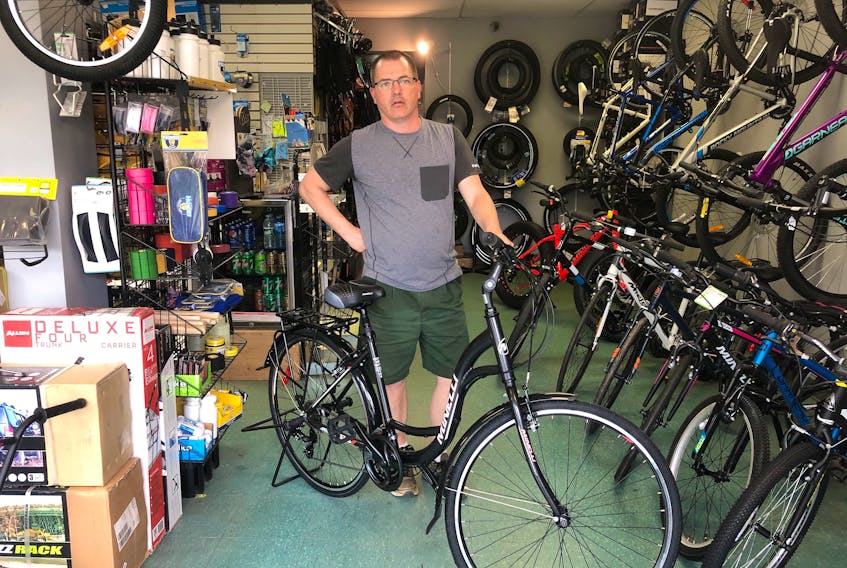 Owner Basil Hicks shows off one of the bikes inside Bicycle Specialist & Sport in Amherst. CONTRIBUTED