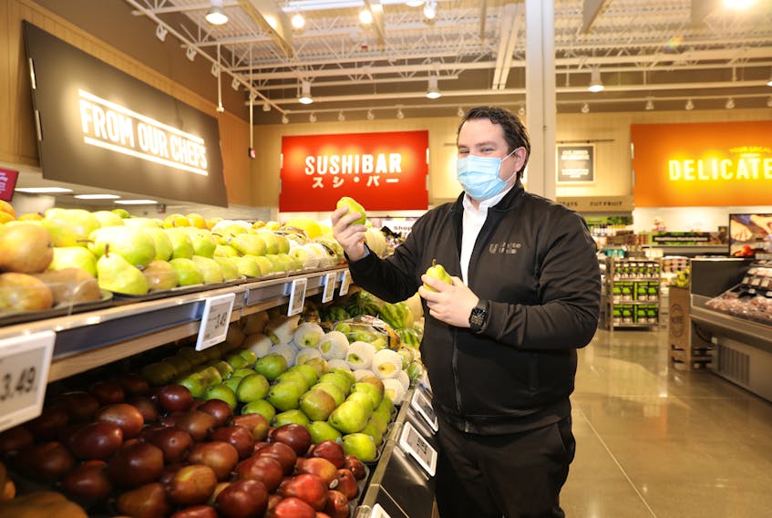 Atlantic Superstore manager Greg Bourque was thrilled to participate in the recent opening of the new Larry Uteck store. He put a few finishing touches on the produce section. - Kelly Clark Fotography