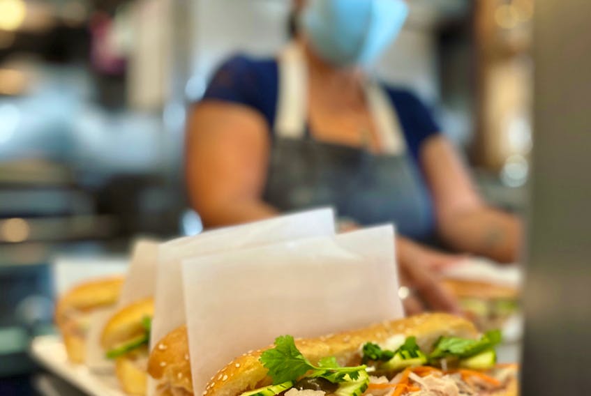 In the foreground, sandwiches are made daily with freshly baked organic bread at the A Good Day Kitchen & Café in Fall River, N.S. Owner Luch MacLellan is pictured in the background. CONTRIBUTED