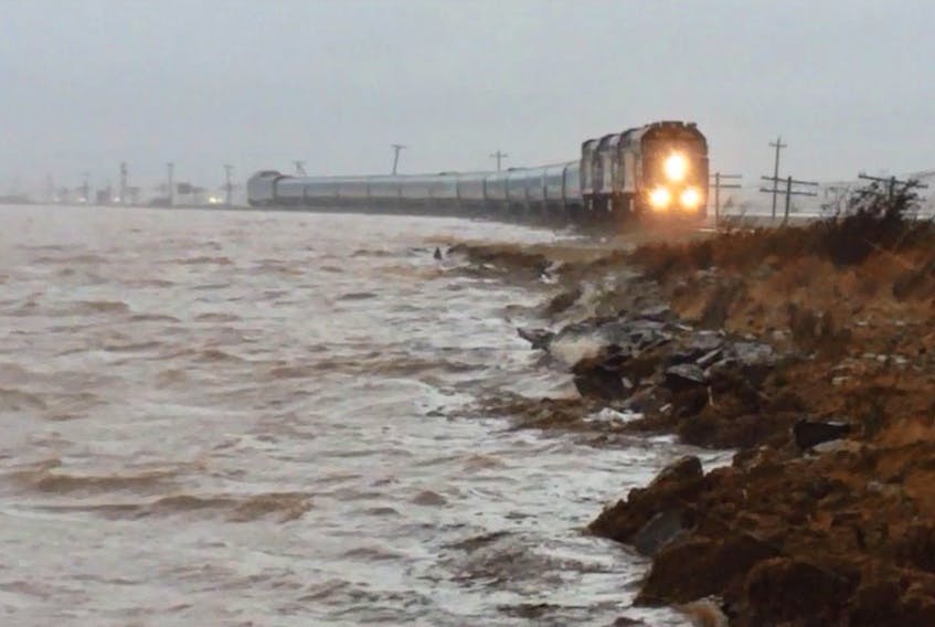 A passenger train makes its way across the marsh in Aulac, N.B. during the King Tides of 2015, when the water from the Bay of Fundy came within a centimetre of breaching the dike that is the rail line. Mike Johnson/Cumberland EMO