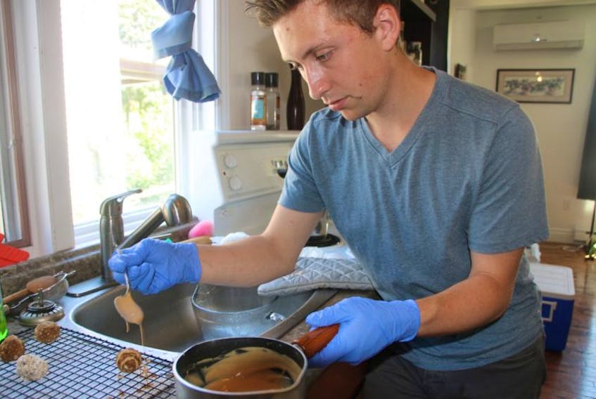Tyler Jollimore pours a peanut butter glaze over Pomace handmade dog treats.