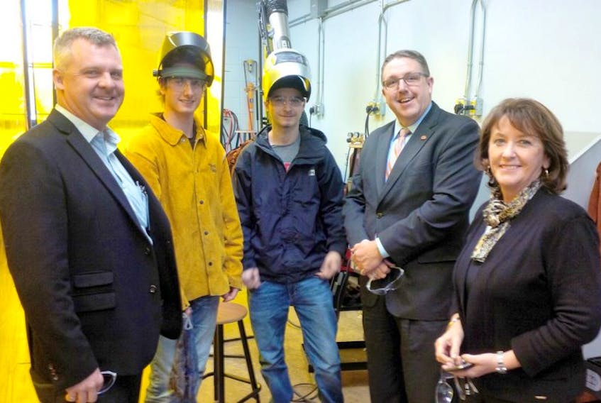 Chamber president Andrew Lake, left, talks with CEC students Christian MacPhee and Colby Tattrie, along with school principal Bill Kaulbach and Education Minister Karen Casey, during the official opening of a new “hot  lab” at CEC which will provide opportunities for students to enhance skilled trades training such as welding.