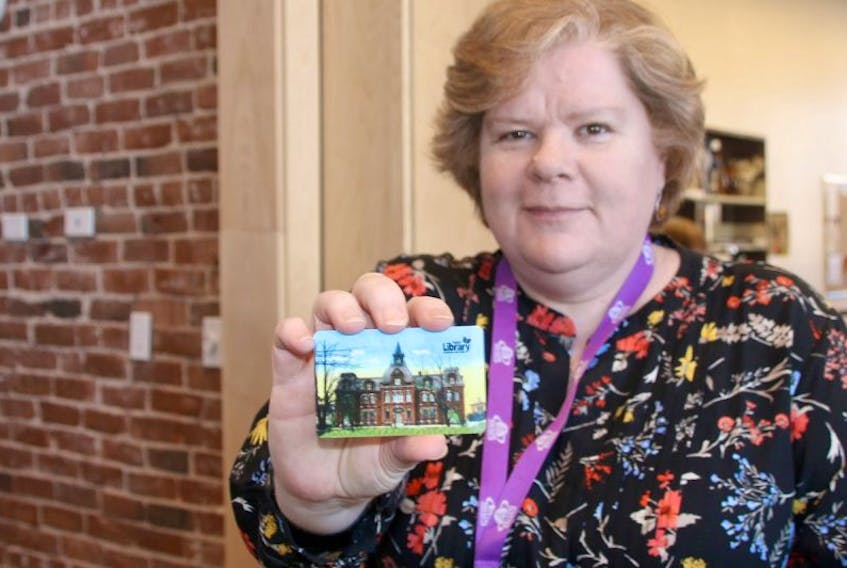 Lesley Brann, administrator of adult and outreach services at the Truro branch of the Colchester-East Hants Regional Library, shows off one of the special edition cards being sold to help raise funds for the building. Cards have almost sold out.