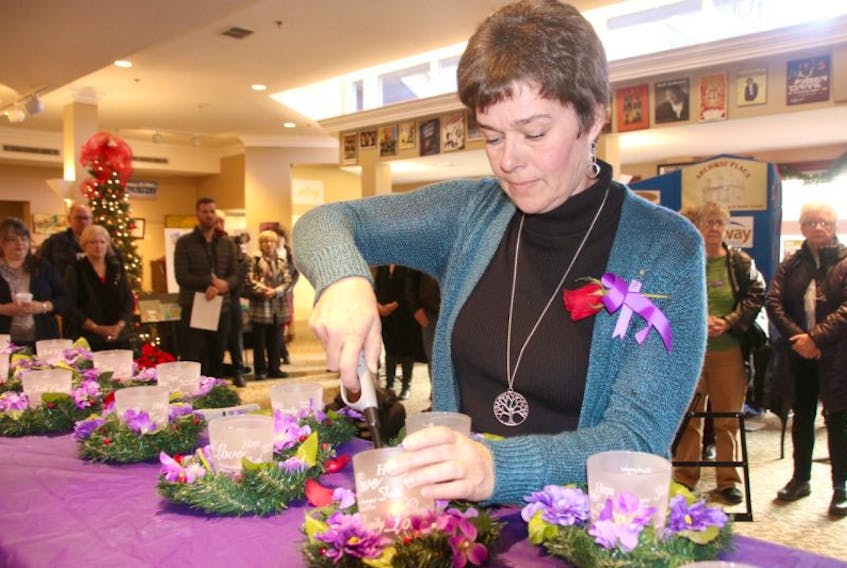 Jackie Waugh lit the candles during the National Day of Remembrance and Action on Violence Against Women ceremony at the Marigold Cultural Centre on Tuesday.