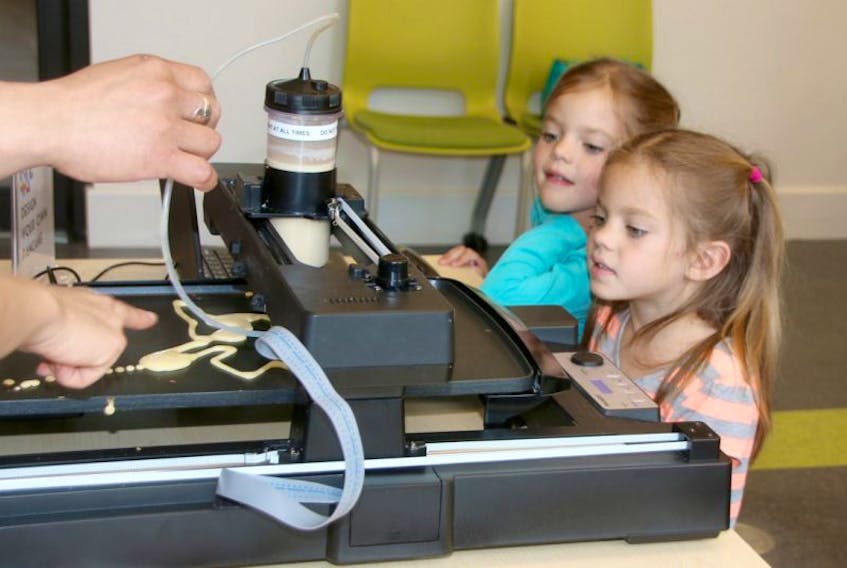 Four-year-old twins Lexi and Nadia Mills got a close-up look at the PancakeBot in action. Using special software, the machine prints pancakes from anyone’s design.
