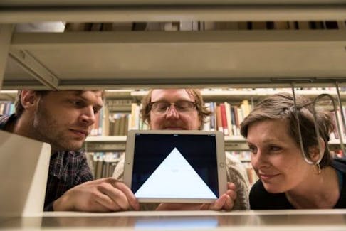 (from left) Ned Zimmerman, Alex McLean and Susan Leblanc show one of the iPads used in the Archive of Missing Things at the Killam Library Friday.