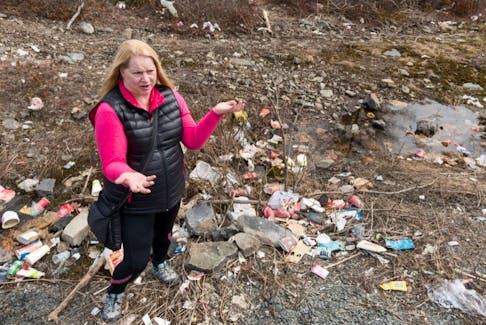 Toni Stewart talks about the garbage behind her, near Halifax West High School, on Monday.