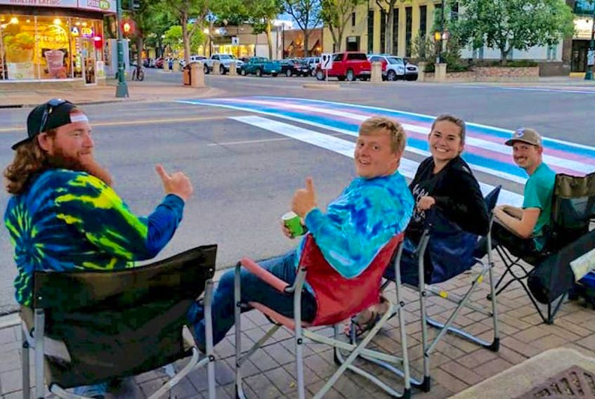 Sean Steacy, left, and Peter Millman, next to him, with a couple of those who joined them in guarding the crosswalks painted for Lethbridge Pridefest.
