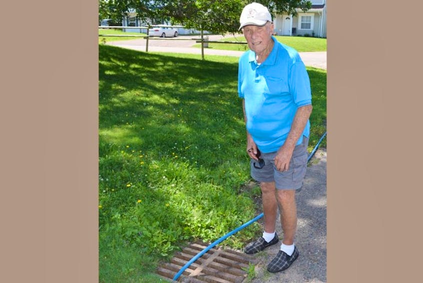 Truro resident Jack Ethier checks out a temporary fix the town has used on a fire hydrant to keep chlorine at the proper levels. He calls the effort a band-aid solution and feels it has taken too long to repair.