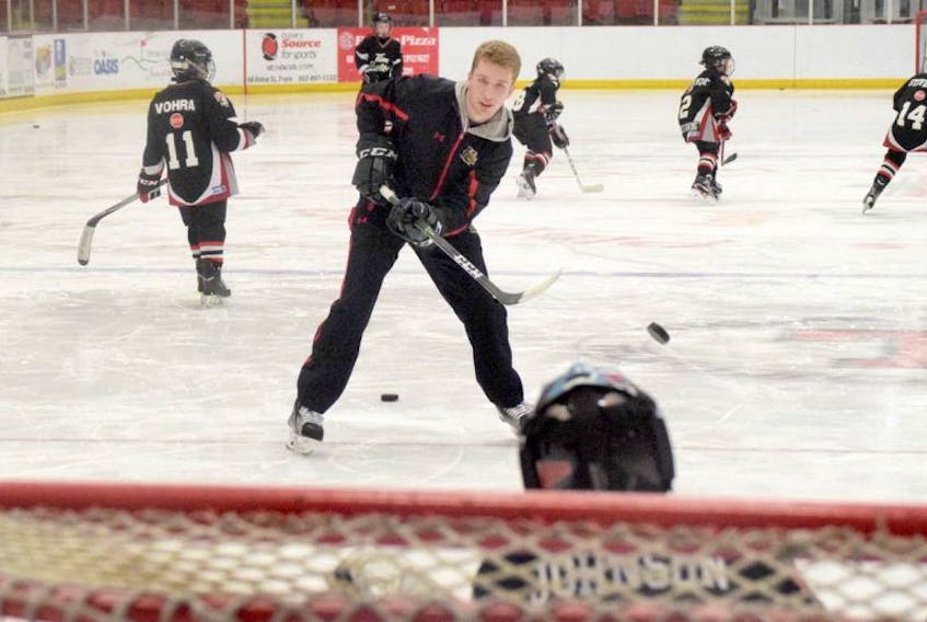 Truro native Jared McIsaac, a defenceman for the Halifax Mooseheads QMJHL team, warms up Truro Bearcats advanced novice goaltender James Johnson during a practice session on Monday in Truro.
